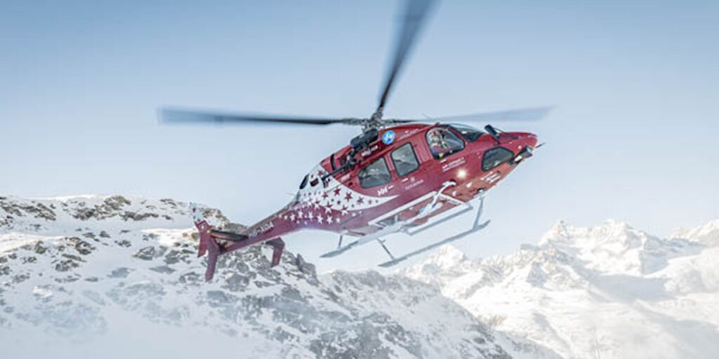 Air Zermatt Helikopter vor verschneiten Berggipfeln
