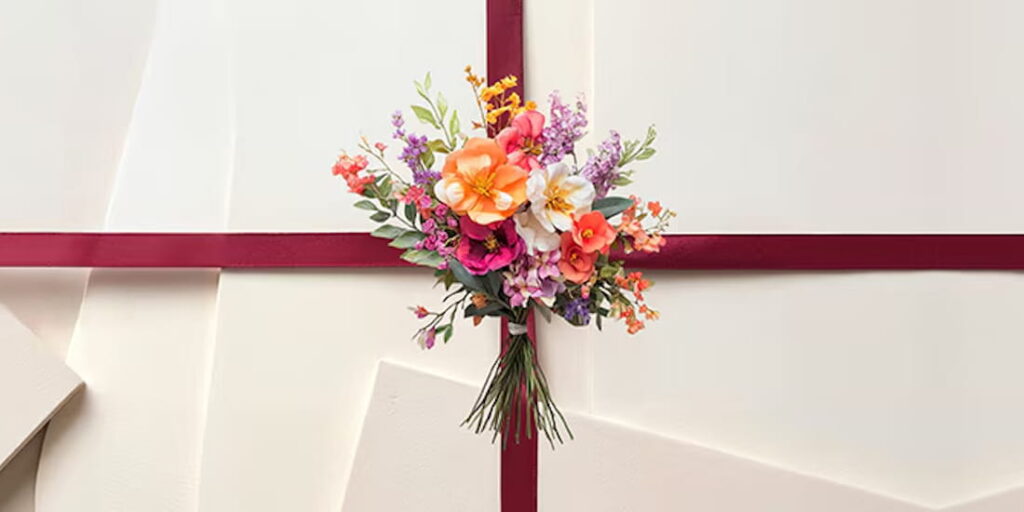 Marionnaud Wettbewerb zum Muttertag 2026 – farbenfroher Blumenstrauss mit dunkelroter Schleife auf weissen Papierbogen